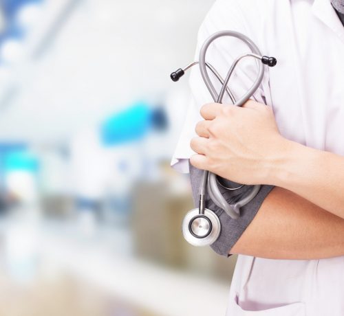 doctor-with-stethoscope-hands-hospital-background-scaled.jpg